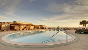 A swimming pool with lounge chairs and a covered seating area. - Islander Hotel & Resort (Emerald Isle)