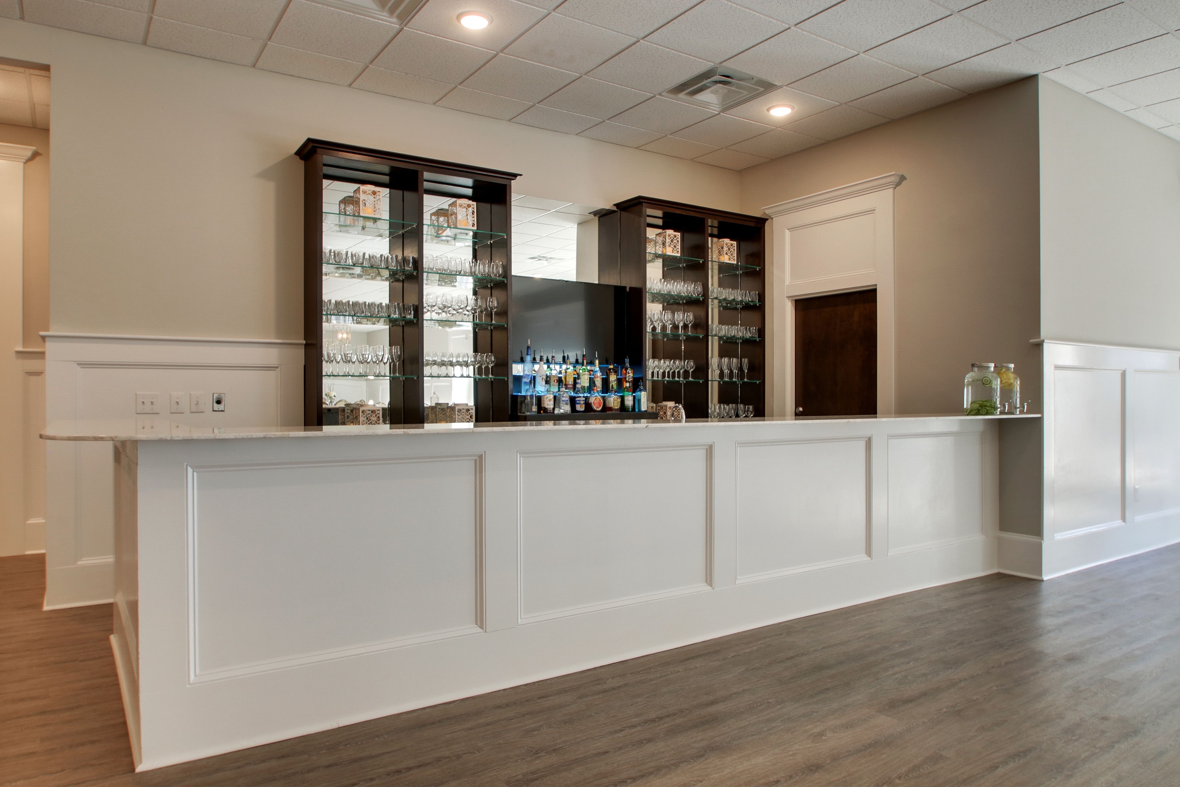 A reception area with a counter, glass display cases, and a wooden door.