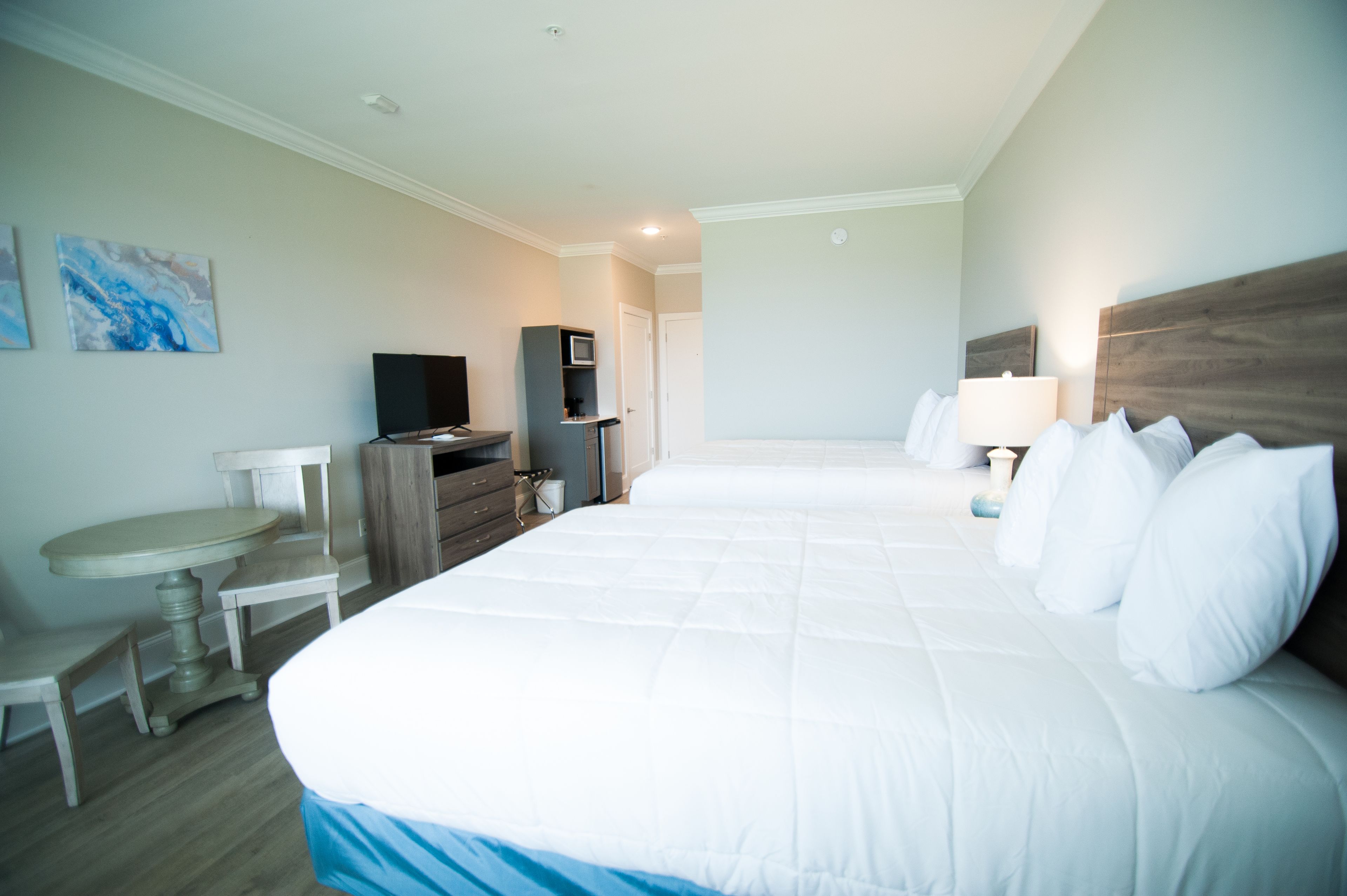 Une chambre d’hôtel avec un grand lit, un bureau, une télévision et un petit coin salon.