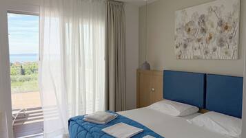 Una habitación de hotel con cama, vistas al exterior y un cuadro en la pared.