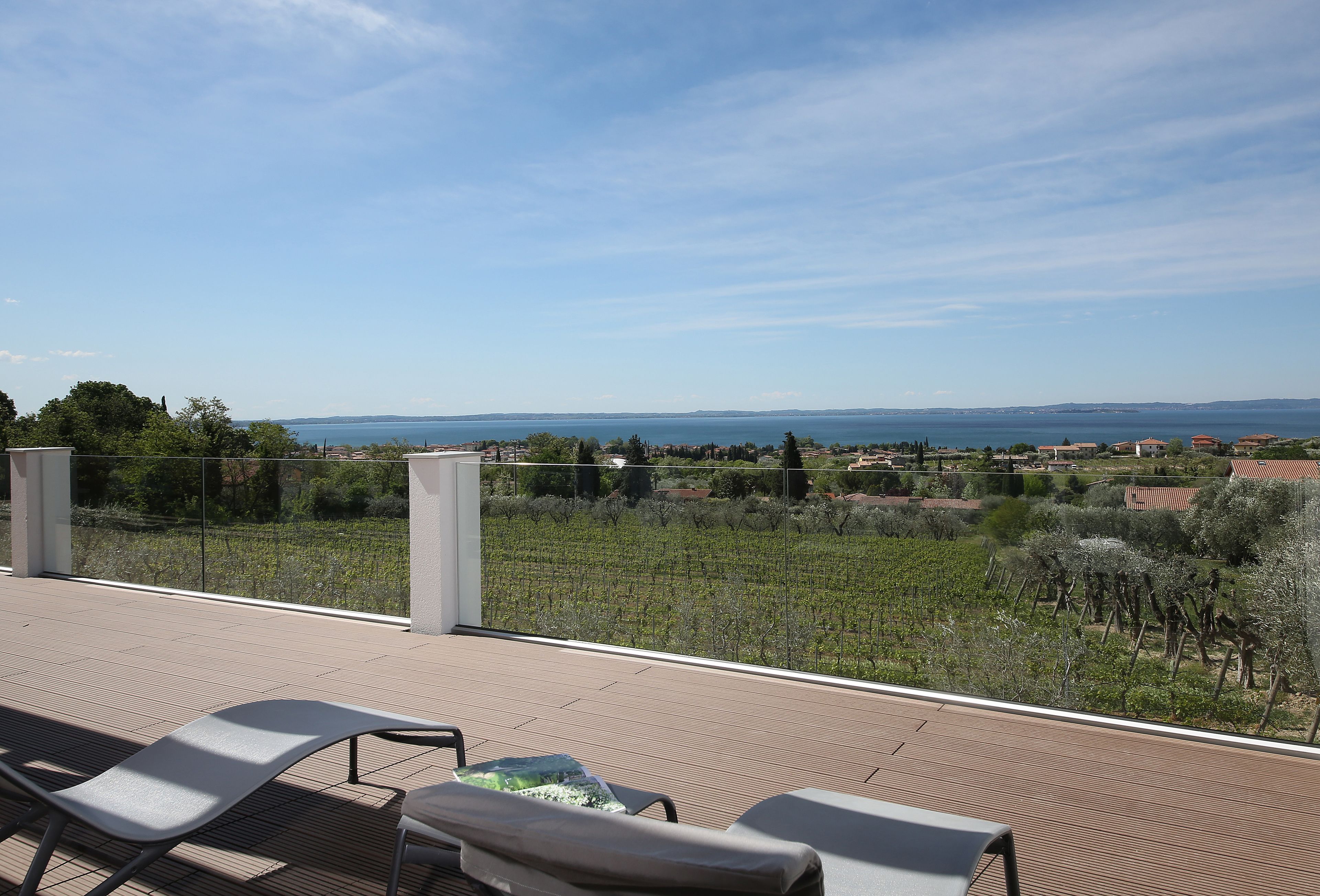 Une terrasse offrant une vue sur un vignoble et un paysage lointain.