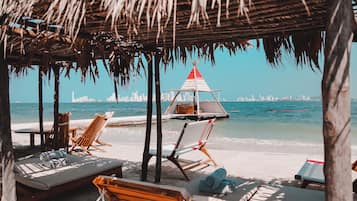 On the beach, white sand, beach cabanas, sun-loungers