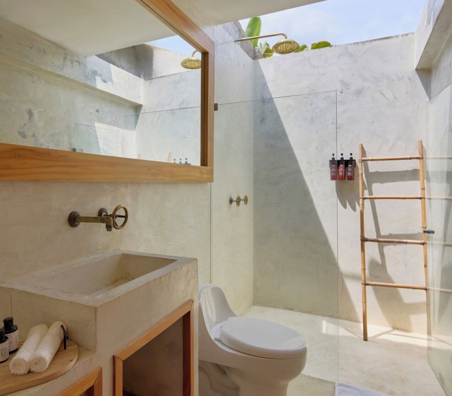 A modern bathroom with a large sink, toilet, and shower area.
