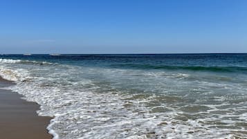 Ubicación cercana a la playa, arena blanca y toallas de playa