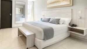 A modern bedroom with a large bed, bedside tables, a bench, and a painting on the wall. - Danieri Asunción Hotel (Asunción)