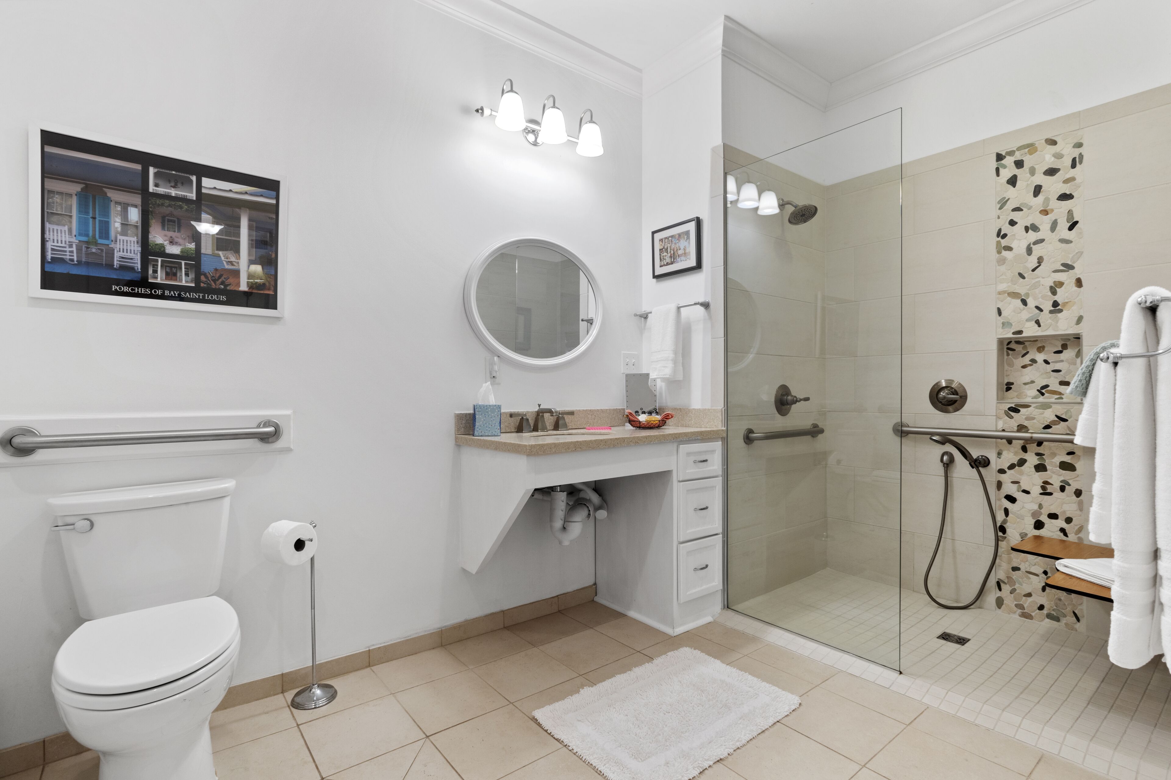 A modern bathroom with a toilet, sink, mirror, and glass-enclosed shower.