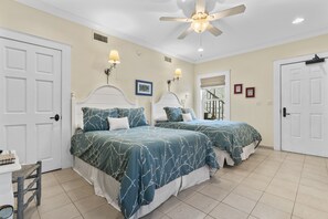 A bedroom with two beds, white headboards, and matching blue bedding.