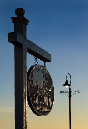 A sign for Bay Town Inn Bed & Breakfast with a lamp post in the background.