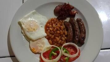 A plate with eggs, sausages, beans, and tomatoes.