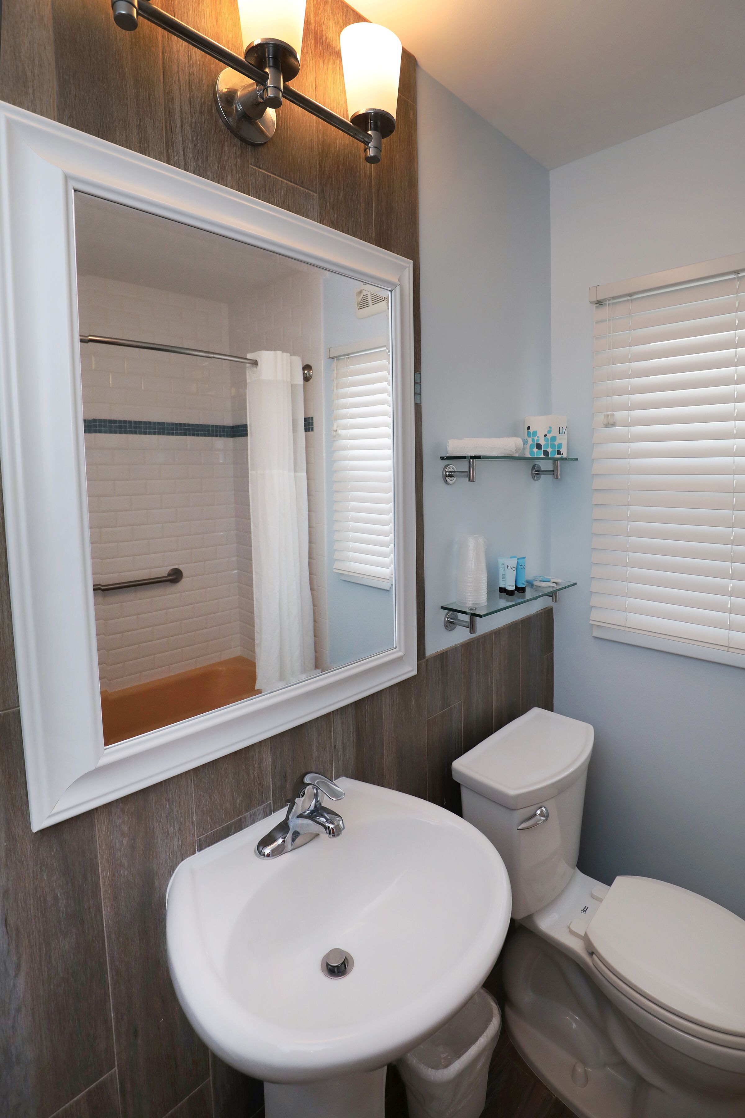 A bathroom with a white sink, a toilet, a shower with a glass door, and a mirror above the sink.