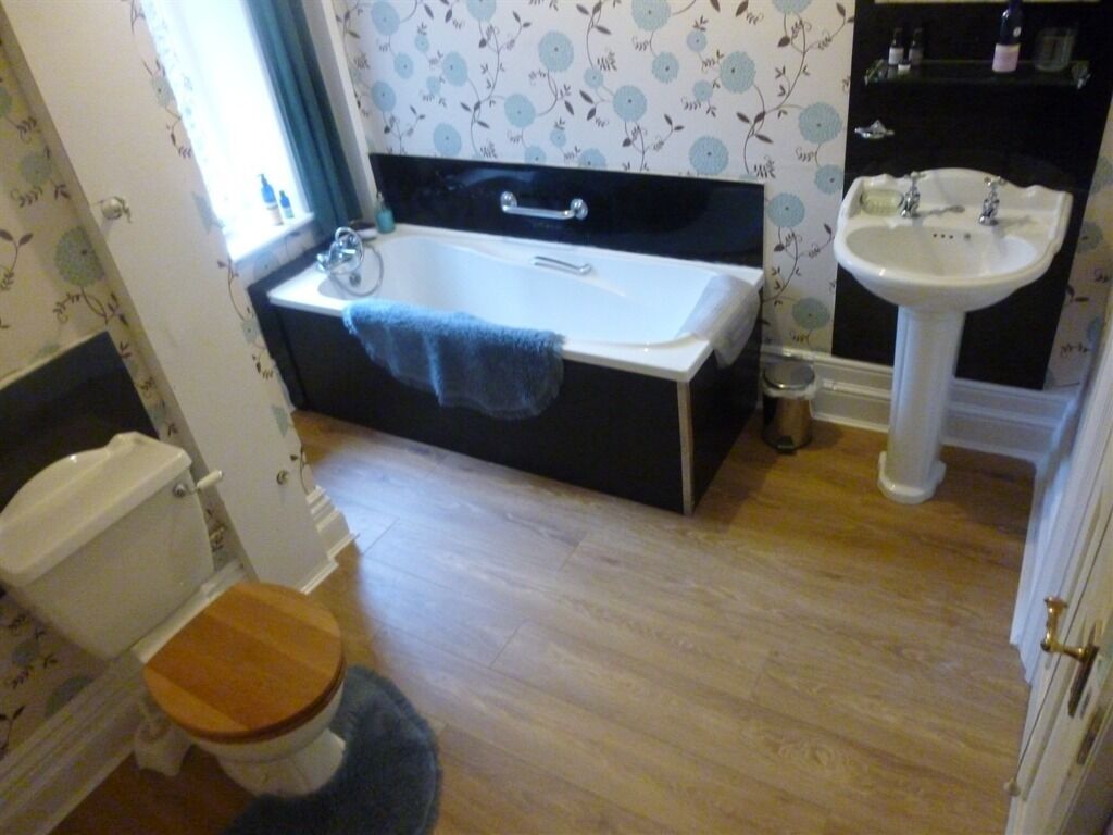 A bathroom with a bathtub, a toilet, and a sink.