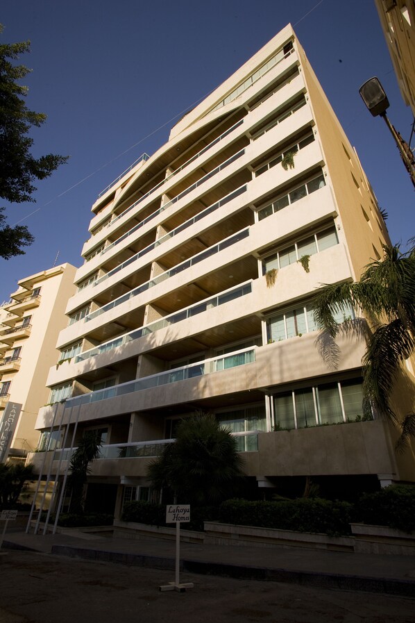 A multi-story building with balconies, a sign indicating 'Lahoya Homes', and a clear sky. - Lahoya Homes (Beirut)