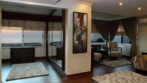 A modern living room with a large window, a painting, and a sofa. - Lahoya Homes (Beirut)