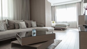 A modern hotel room with a sofa, a bed, a dining area, and a kitchen. - Lahoya Homes (Beirut)