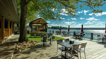 Terraza de madera con asientos exteriores y vistas al lago.