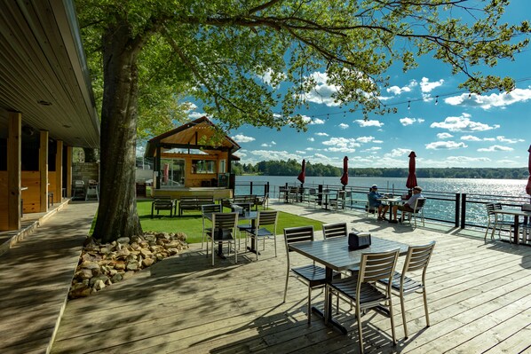 A wooden deck with outdoor seating and a view of the lake.