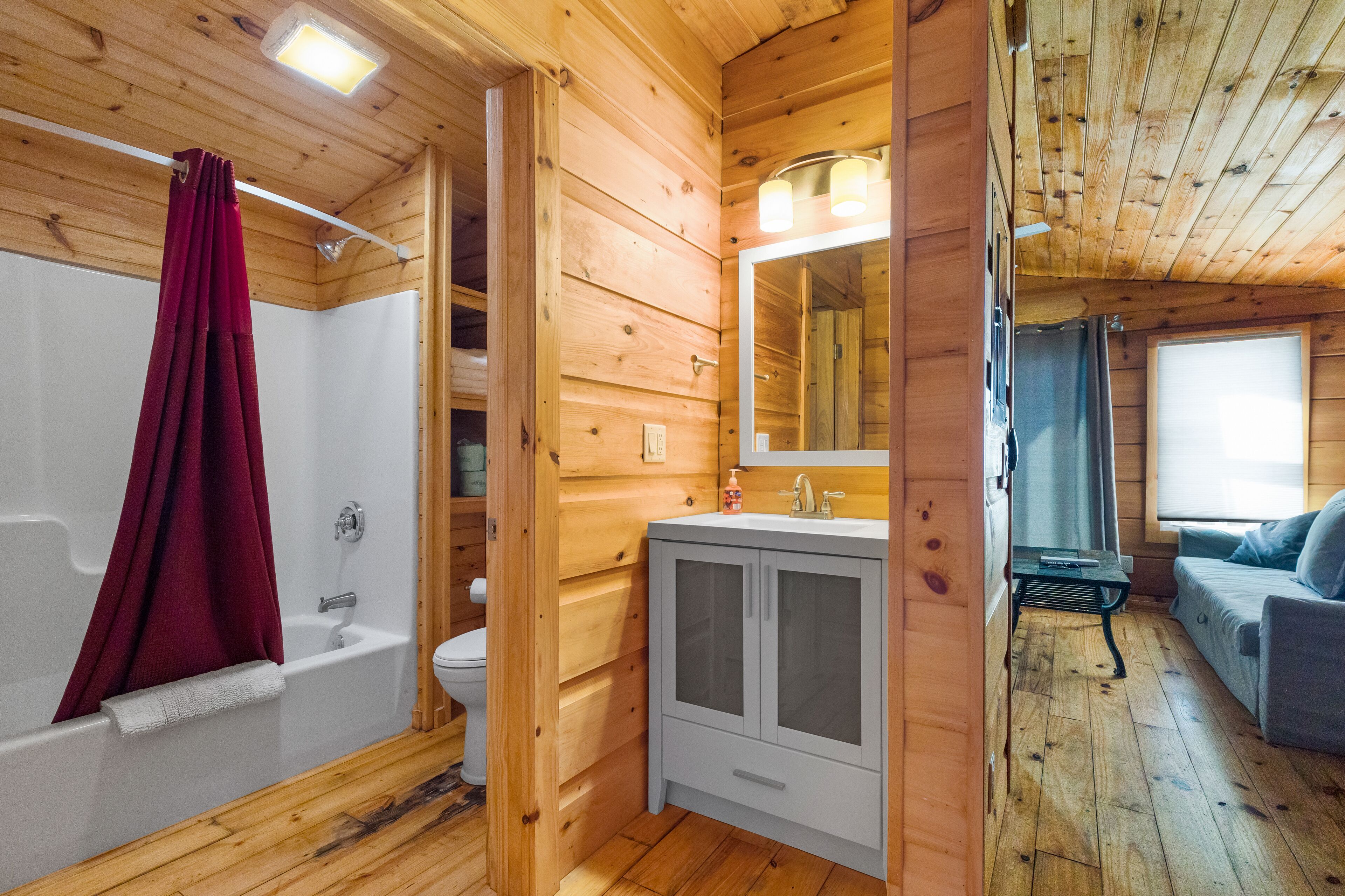L’intérieur d’une cabane en bois comprend une salle de bain équipée d’une baignoire, de toilettes et d’un meuble-lavabo.