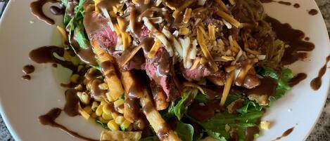 Un plato de comida con bistec, papas fritas y ensalada.