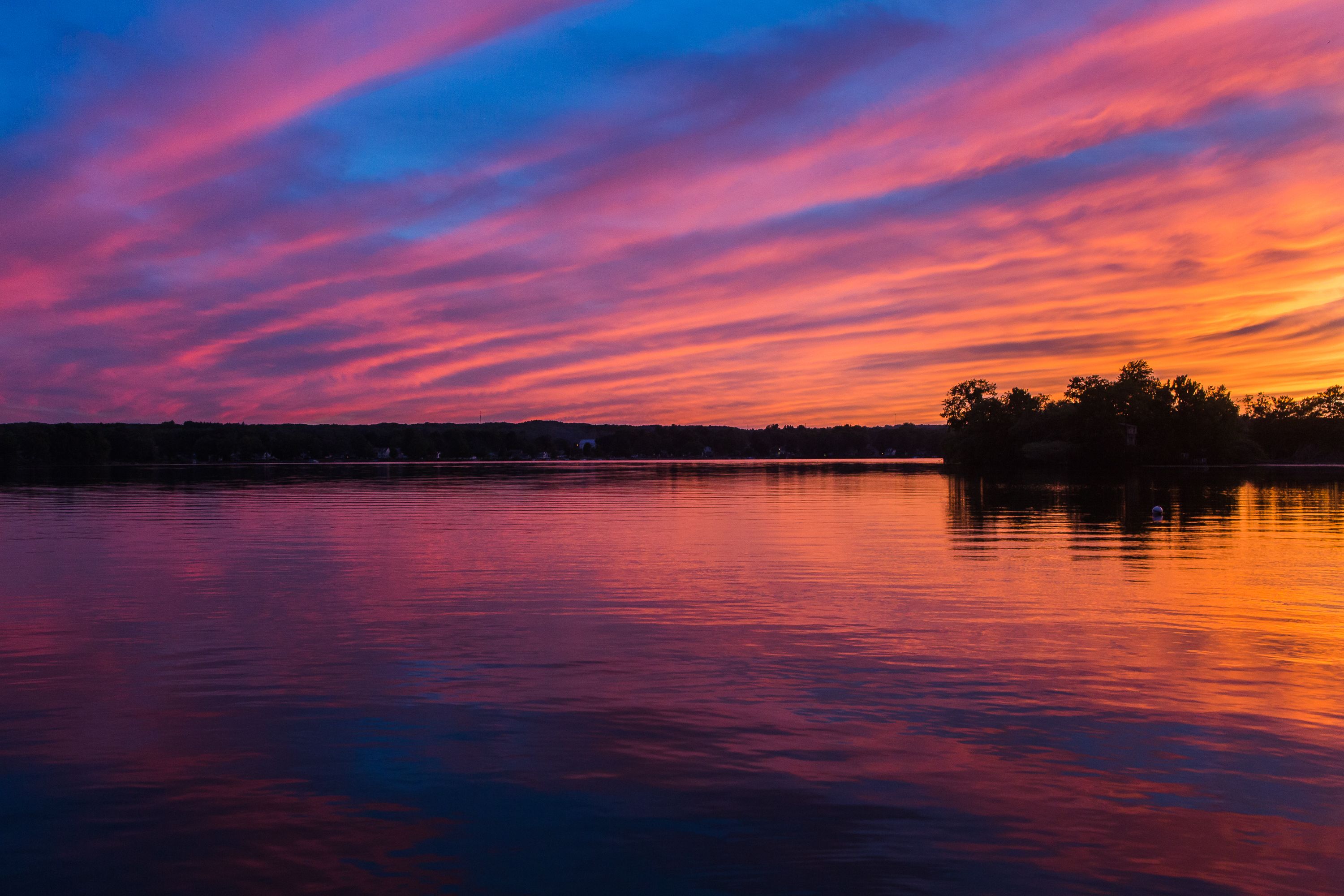 Un lac paisible au coucher du soleil, avec un ciel aux couleurs éclatantes.