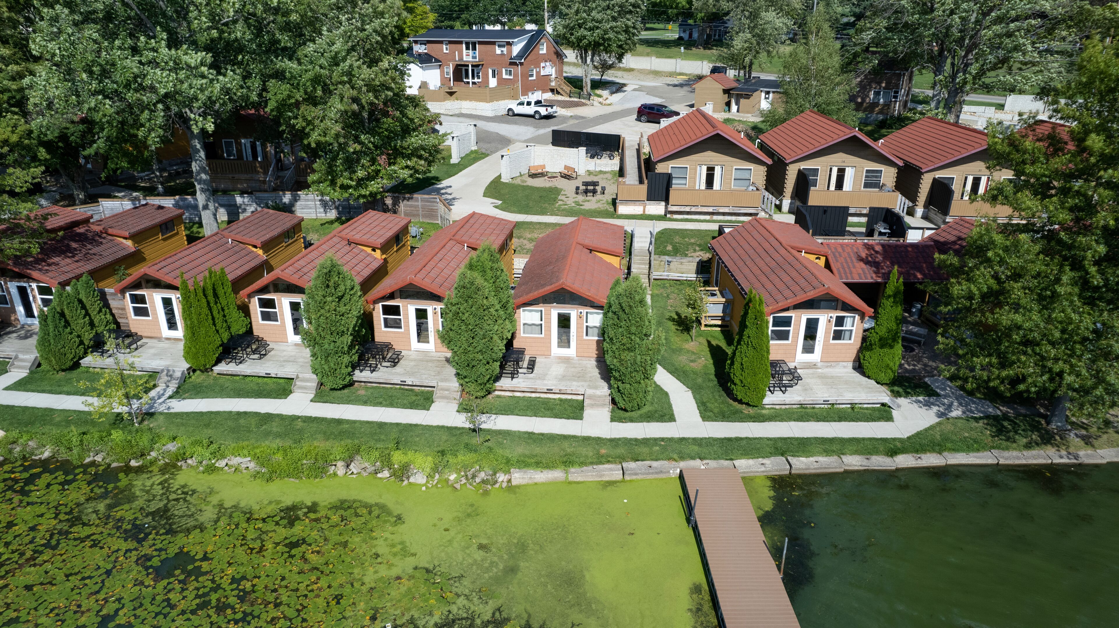 A residential area with multiple houses featuring red roofs and wooden exteriors.