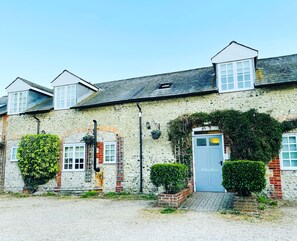 A row of houses with stone walls, a blue door, and a small garden area in front. - Greyhound Inn (Dorchester)
