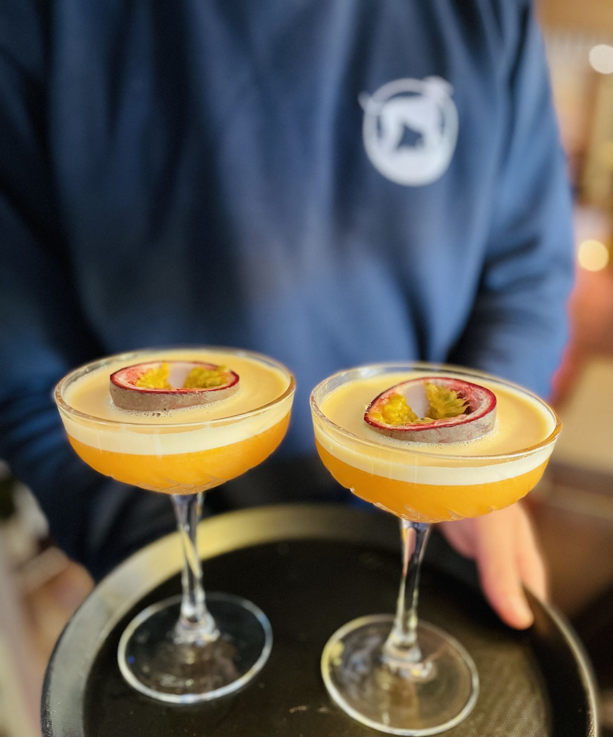 Twee cocktails met fruitdecoraties op een dienblad.