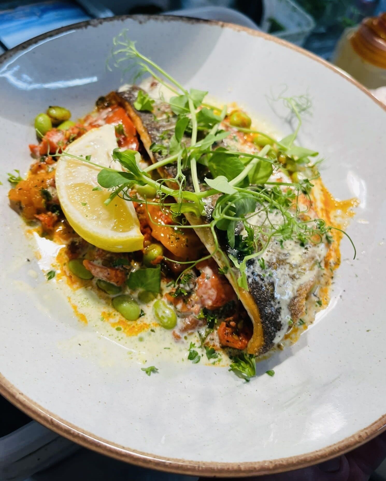 En tallerken mad med fisk, grønt og citron.