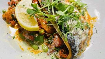 En tallerken mad med fisk, grønt og citron.