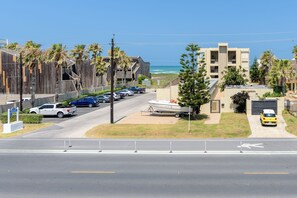 A coastal road with parked cars, a boat trailer, and a building named "Santa Barbara". - Beachview by South Padre Condo Rentals (South Padre Island)