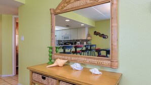 Une console en bois agrémentée de paniers tressés, d’un miroir et d’objets décoratifs.