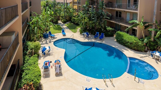 Un espace piscine d’hôtel comprenant plusieurs chaises longues et une petite piscine.