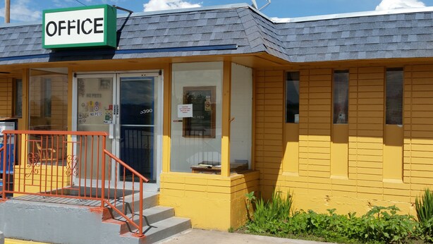 A yellow building with a sign reading "OFFICE" at the entrance. - Essex House Motel (Littleton)