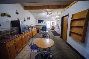 A kitchen with wooden cabinets, a microwave, and a ceiling fan. - Westwood Inn & Suites (Kimball)