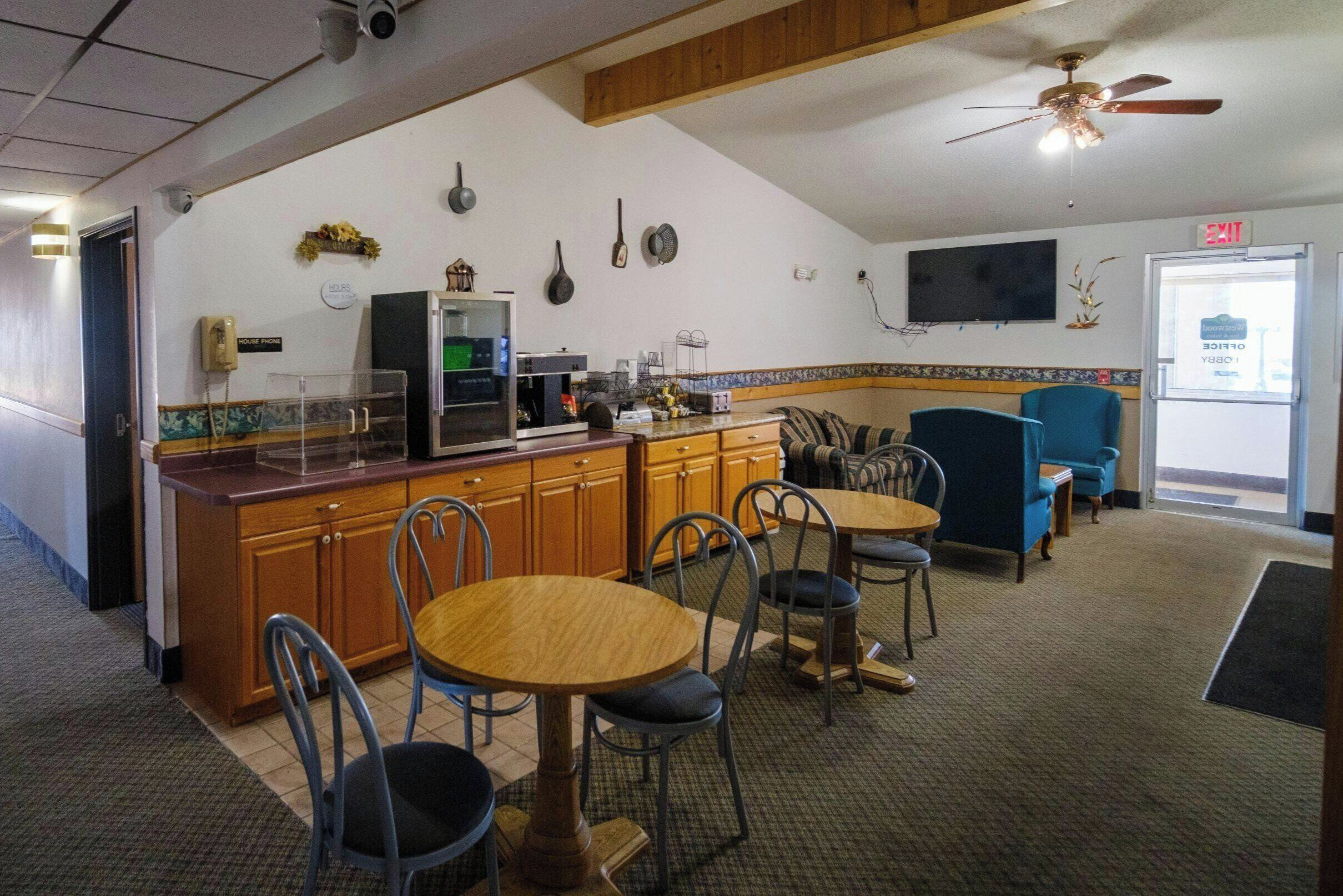 A kitchen with a counter, chairs, and a dining table.