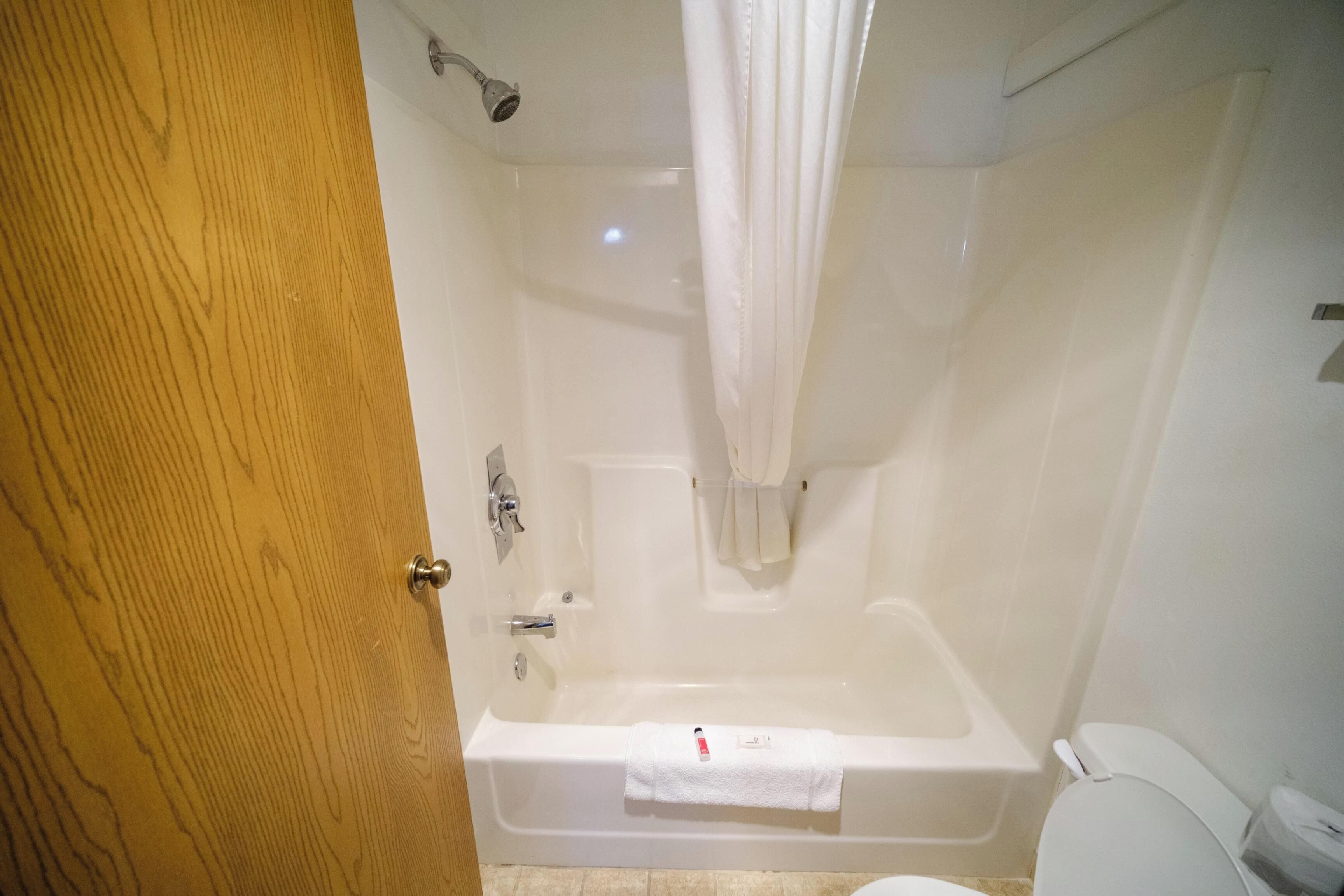 Un baño con bañera, inodoro y cortina de ducha.
