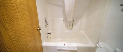Un baño con bañera, inodoro y cortina de ducha.