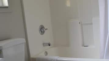 A bathroom with a toilet, bathtub, and shower curtain.