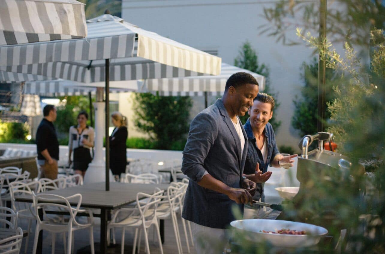 An outdoor dining area with white chairs and striped umbrellas.