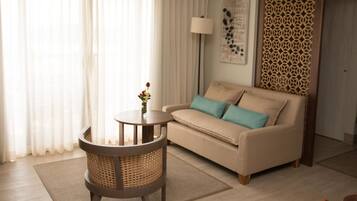 A living room with a sofa, a round table with a vase, and a patterned wall divider.