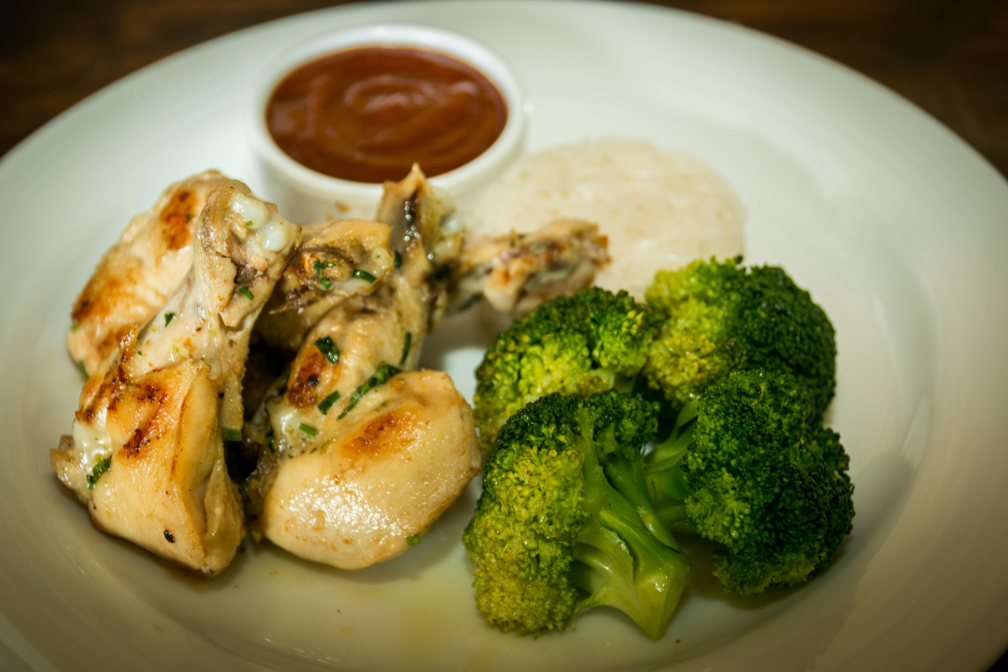 A plate with grilled chicken, broccoli, and a side of rice.
