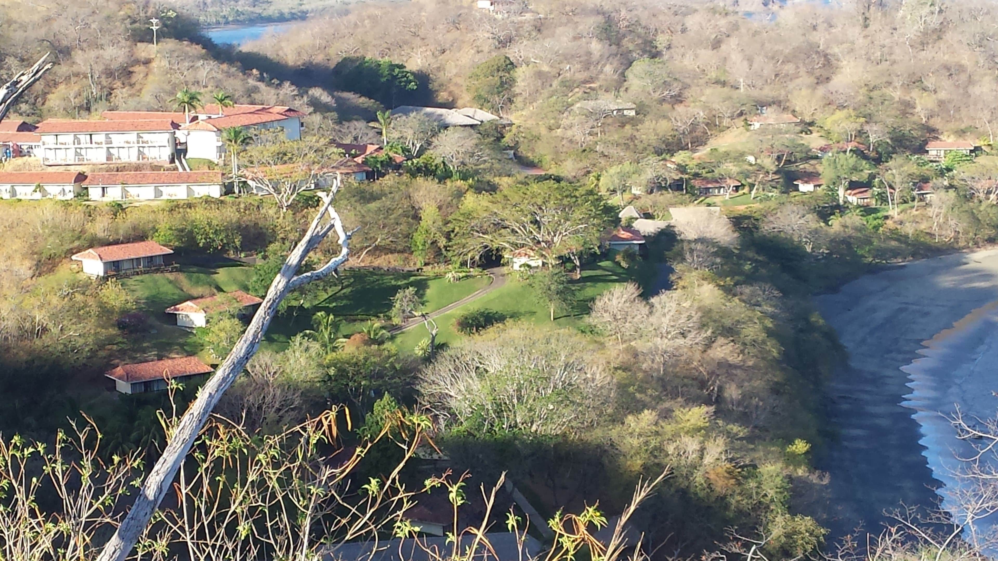 A coastal area with houses and a road leading to the beach.