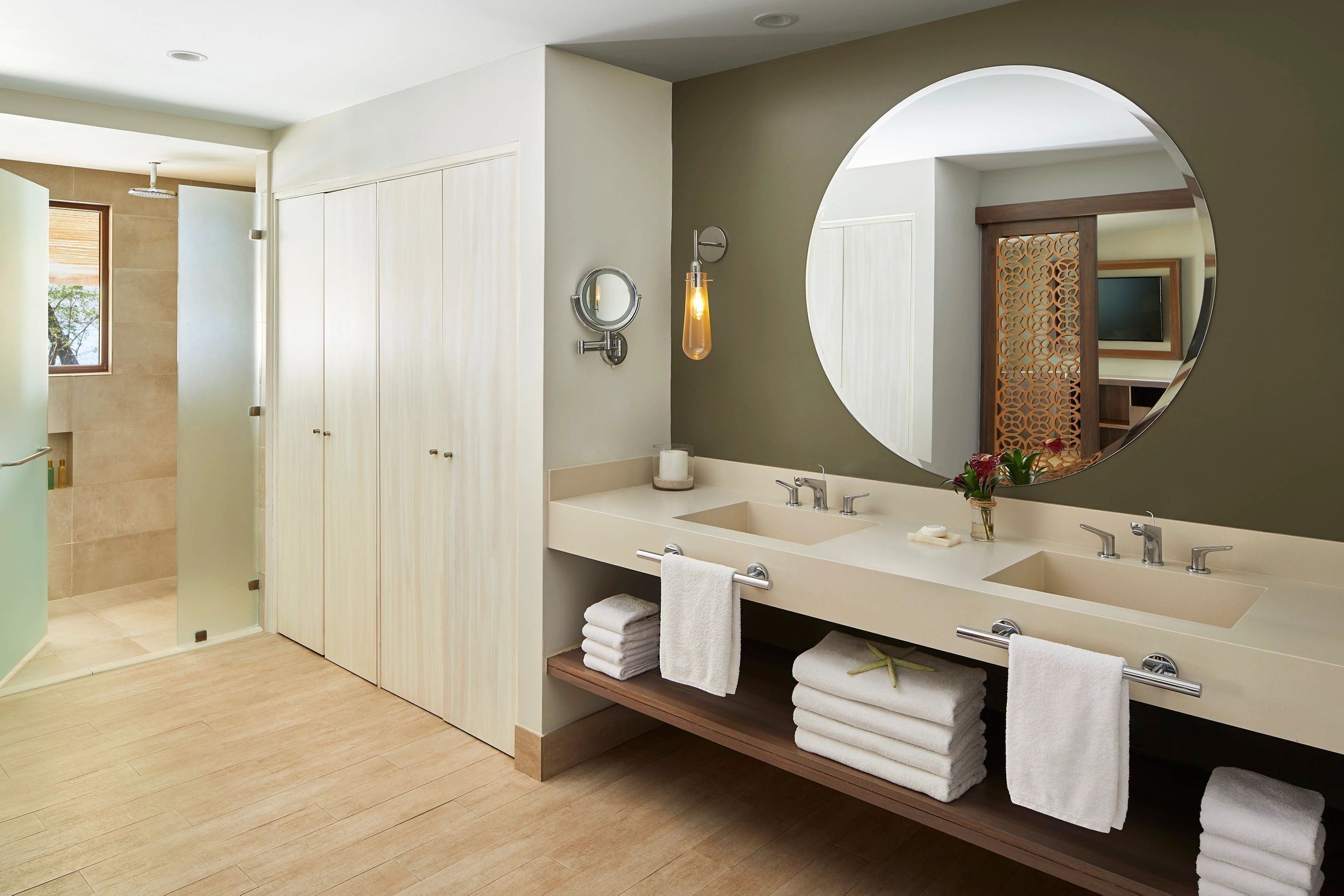 A modern bathroom with two sinks, a large mirror, and a wooden vanity.