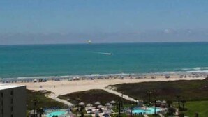 A coastal hotel with a pool area, beach access, and a view of the ocean. - Saida by South Padre Condo Rentals (South Padre Island)