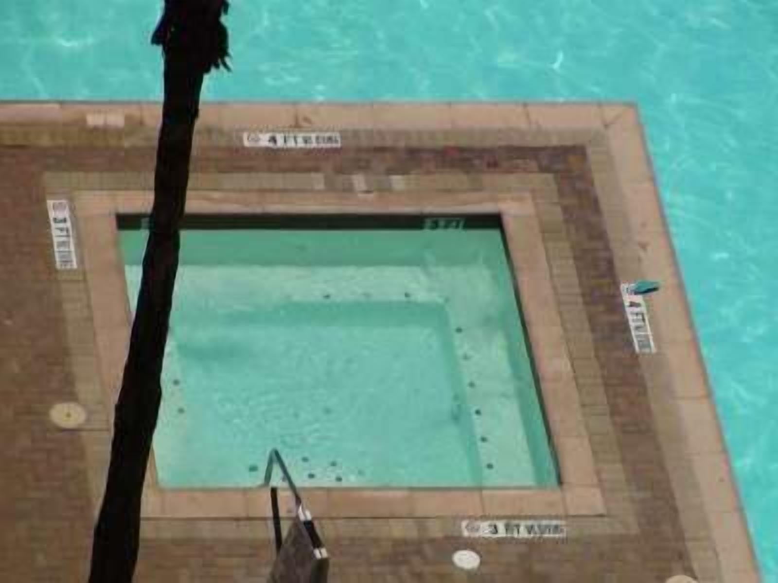 A rectangular pool with a tiled border and a sign indicating a depth of 3.3 meters.