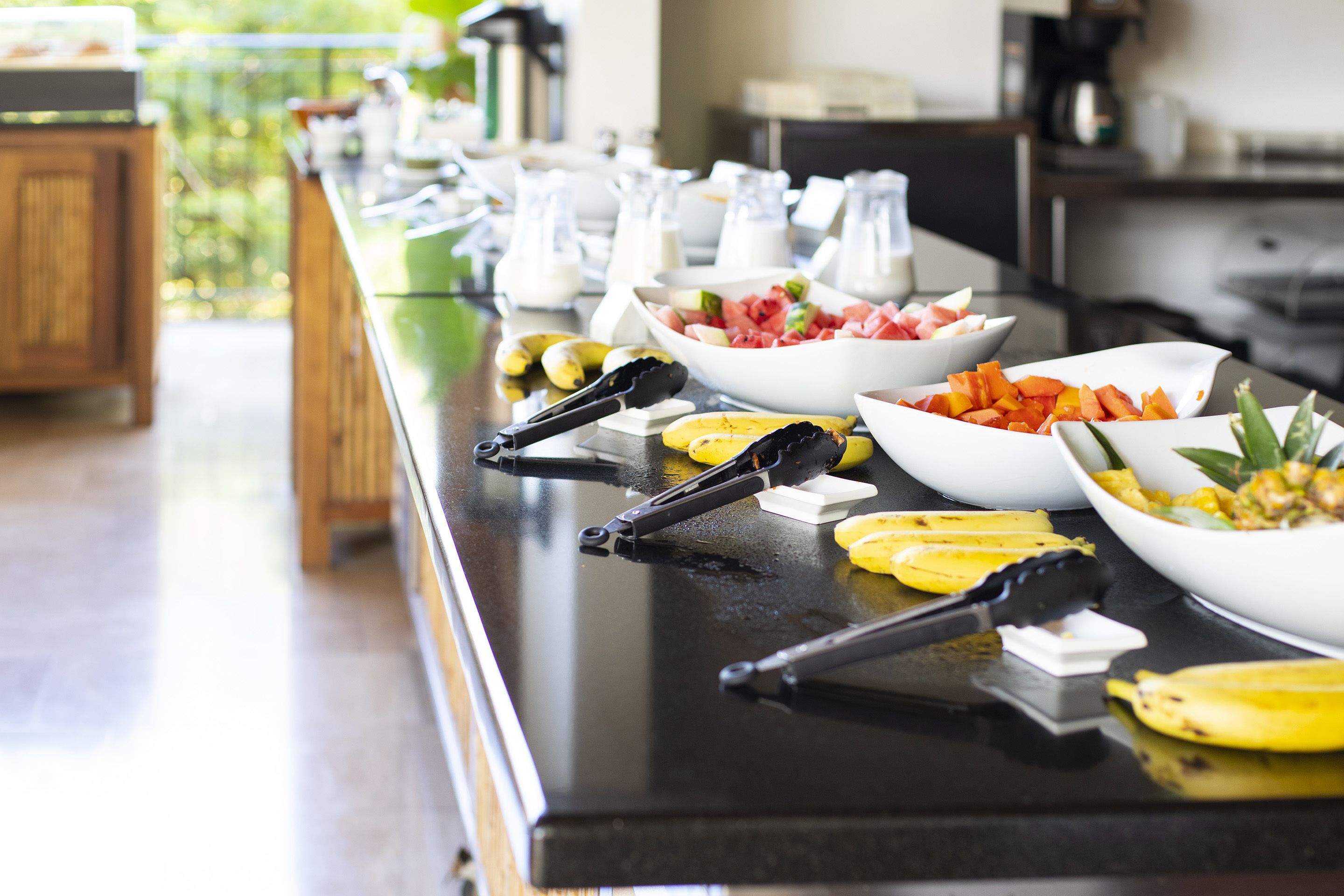 Una mesa de buffet con distintos alimentos y utensilios.