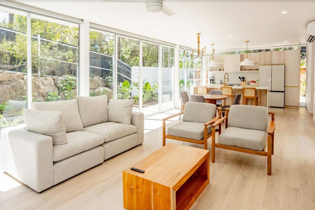 Un salon moderne avec un canapé, des fauteuils et une table basse.