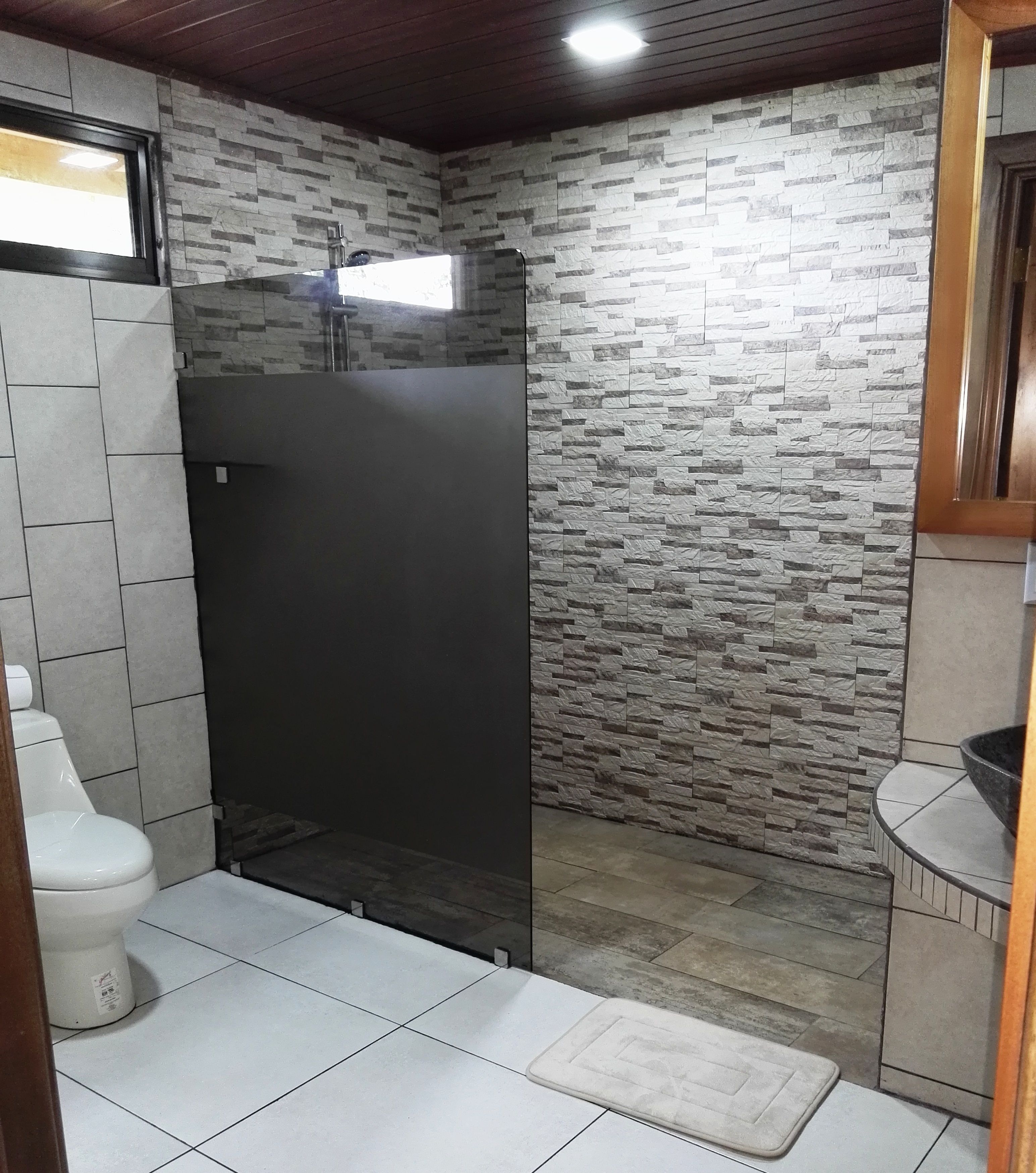 Un baño con ducha, inodoro y lavamanos.
