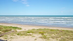 A beach with waves, a wooden walkway, and grassy dunes. - Sea Vista by South Padre Condo Rentals (South Padre Island)