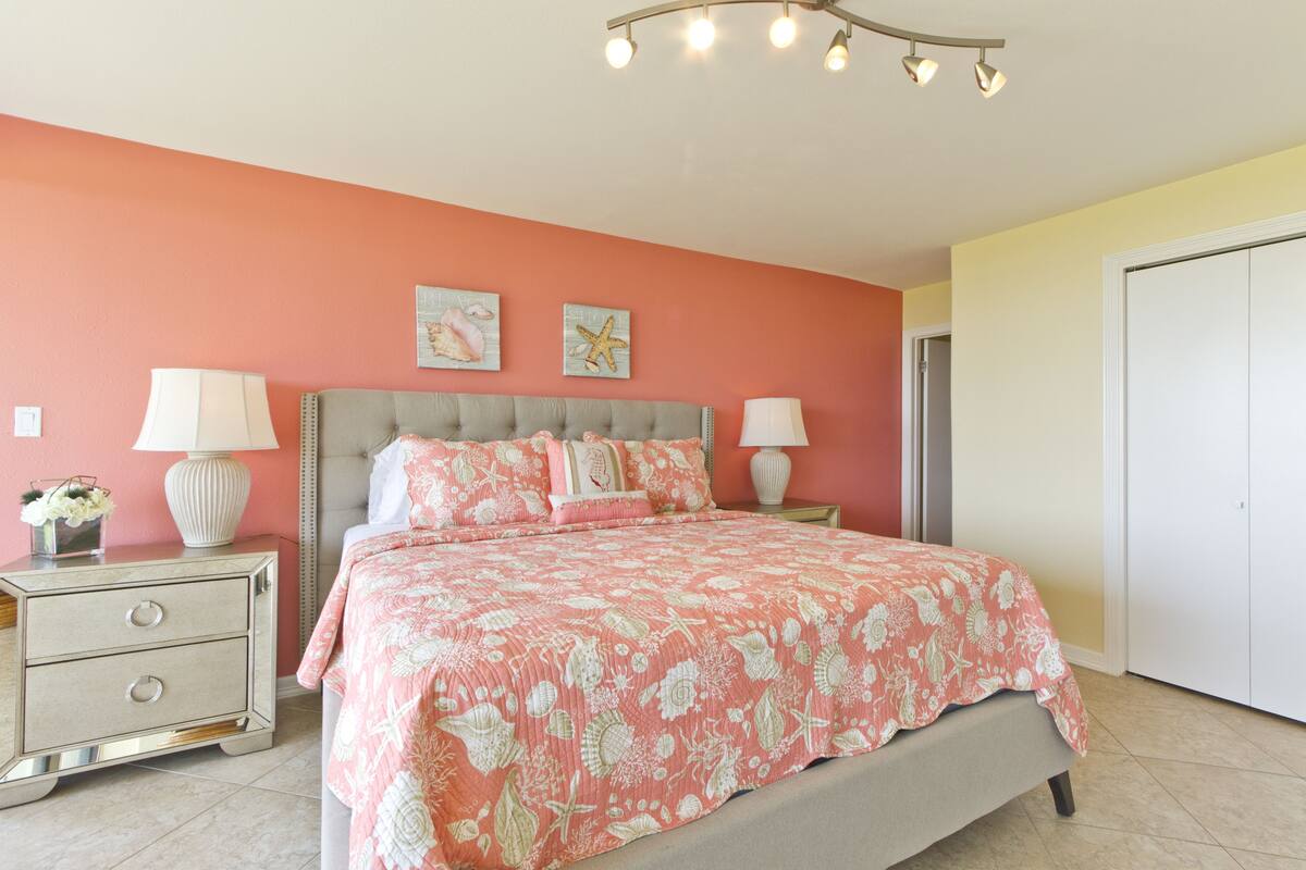 A bedroom with a bed, nightstands, and a wardrobe.