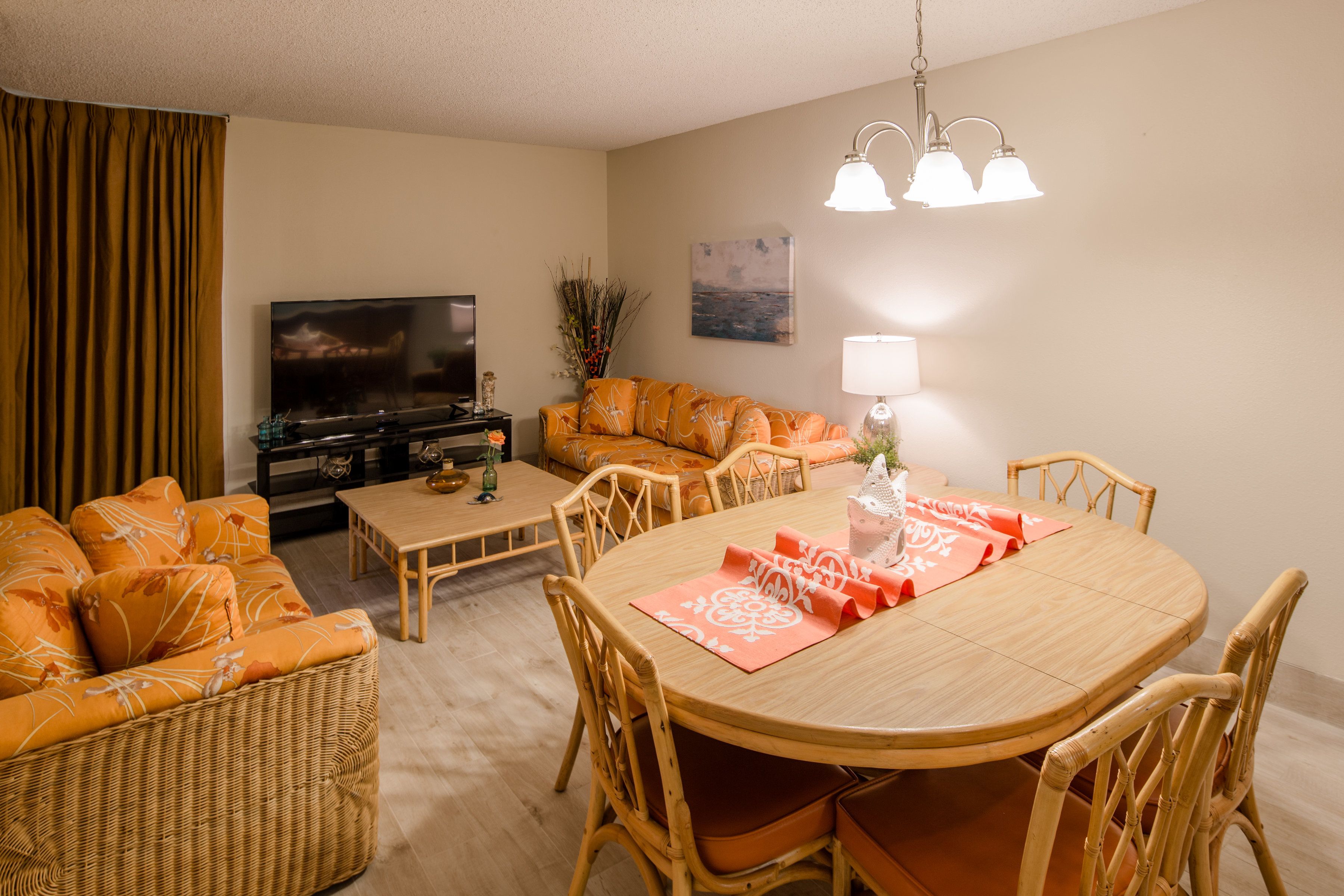 A living room with a sofa, a dining table, and a television.